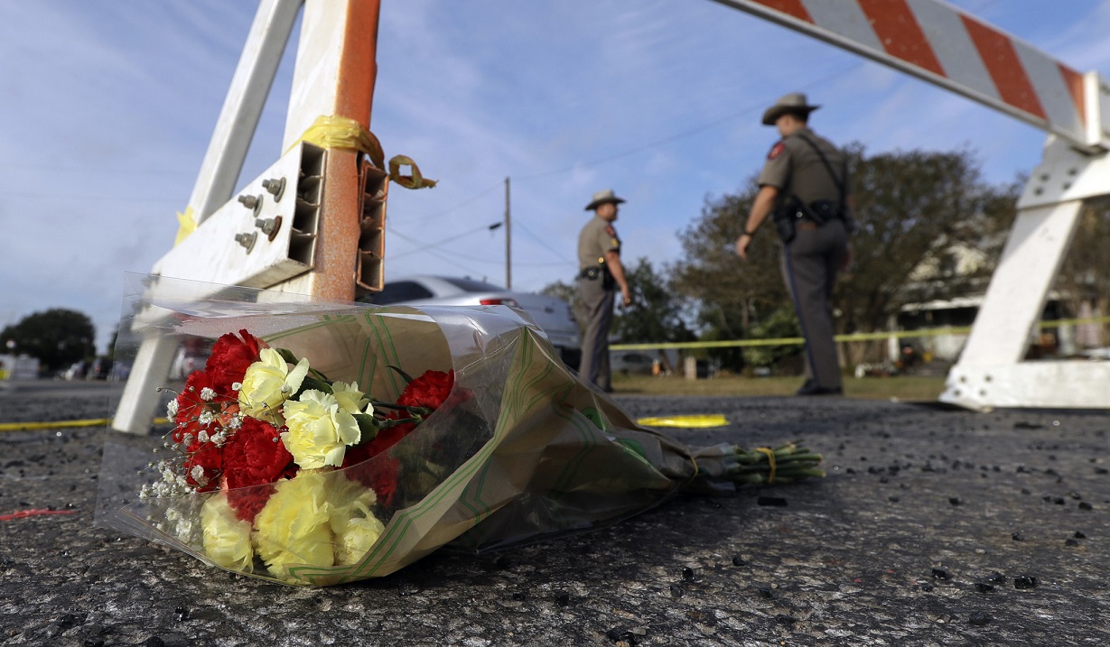 Люди несут цветы к церкви в Техасе, где накануне произошло массовое убийство